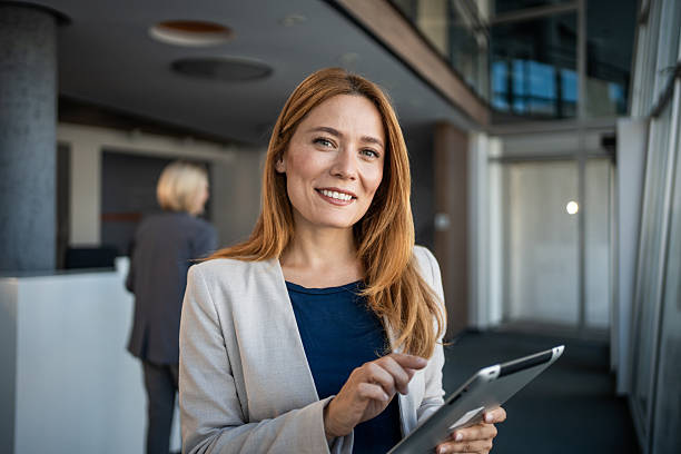 istock Businesswoman smiling and using digital tablet in modern office 2225057218
