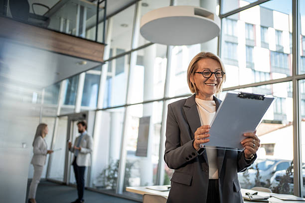 istock Smiling senior businesswoman reading documents in modern office 2225057301