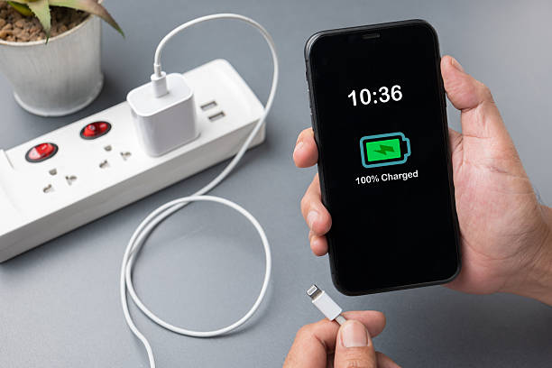 istock Hand Holding Fully Charged Smartphone Unplugging Charger 2225059339