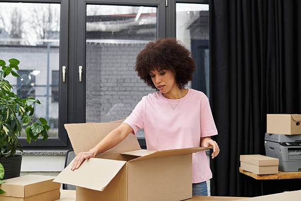 istock Smiling woman packing boxes in a bright modern space during a busy moving day 2225061641