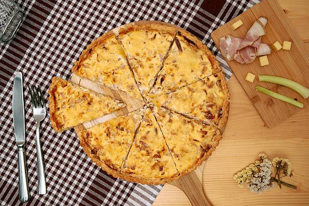 istock Savory quiche with ham and cheese slices on wooden serving board 2225061687