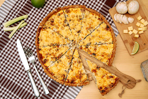 istock Cheese and mushroom quiche with cutting board and utensils on checkered cloth 2225063616
