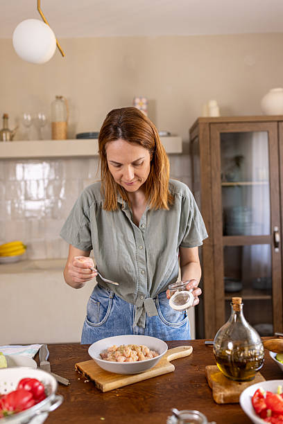 istock Woman putting some spices in a meal 2225063740