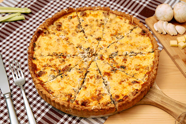 istock Mushroom and cheese quiche on wooden board with checkered tablecloth 2225063936