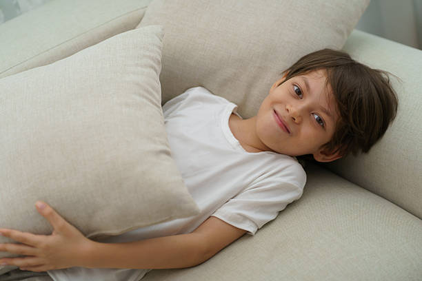 istock A boy is lying on the sofa on a holiday. 2225066125