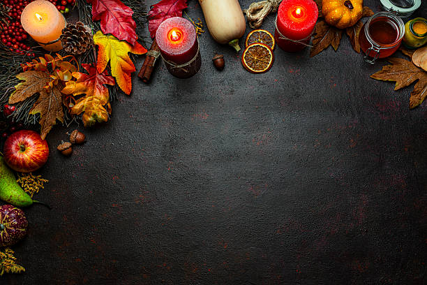 istock Autumn or Thanksgiving border. Decor with burning candles, fallen leaves, nuts, cinnamon sticks and pumpkin. Greeting card or copy space. October or season. Happy Thanksgiving 2225067403