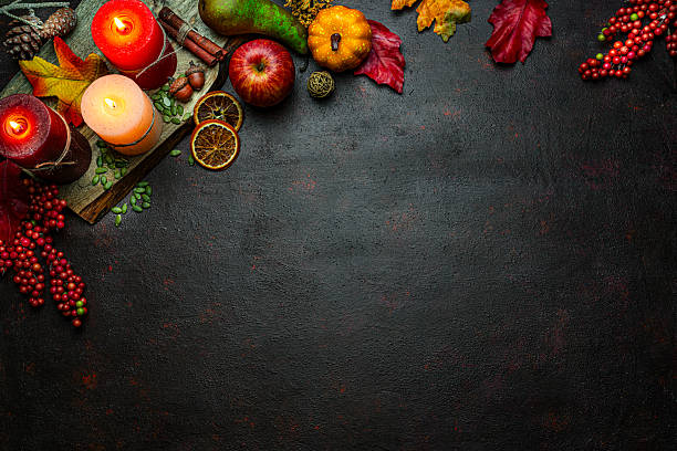istock Autumn or Thanksgiving border. Decor with burning candles, fallen leaves, nuts, cinnamon sticks and pumpkin. Greeting card or copy space. October or season. Happy Thanksgiving 2225067407