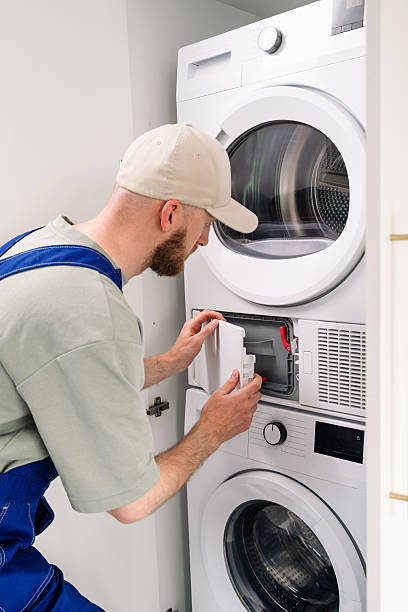 istock Washing machine technician performing maintenance in a modern apartment laundry room 2225069297