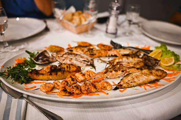 istock Delicious mixed grilled fish platter with scampi, prawns, and lemon 2225072876