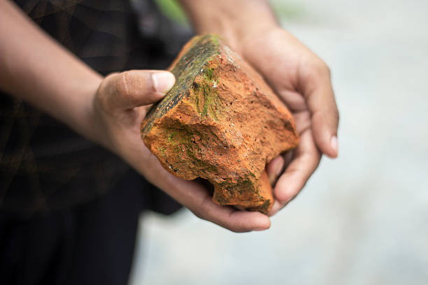 istock A man is holding Broken brick pieces with his hands on the ground 2225073053