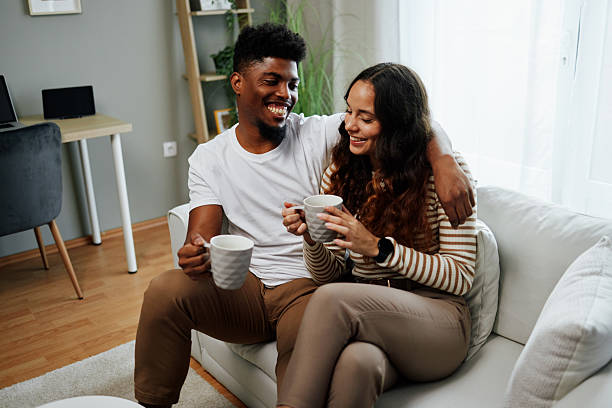 istock Happy couple relaxing on sofa, drinking coffee and enjoying conversation at home 2225074353