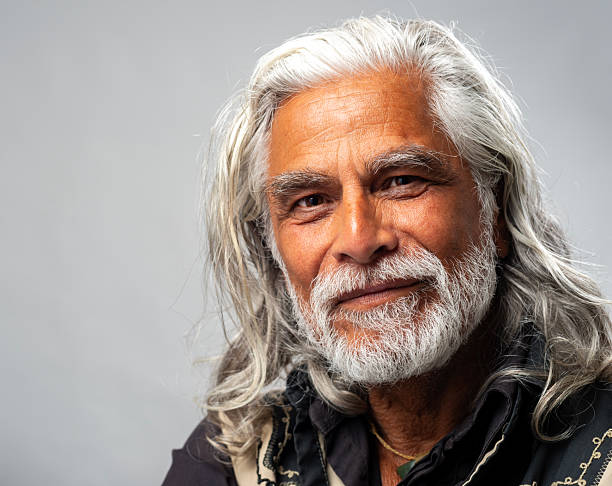 Portrait of a Latin-American senior man with beard and long hair. Smiling  Studio shot.
