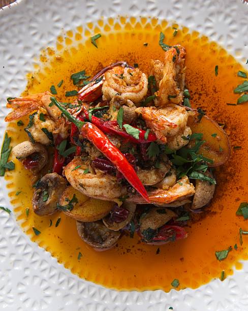 Fried prawns with potatoes and mushrooms at hot chili sauce.