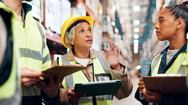 istock Distribution, tablet and team in warehouse, clipboard and conversation with planning for inventory. Group, manager and people in factory, tech and advice for inspection, logistics and quality check 2225078015