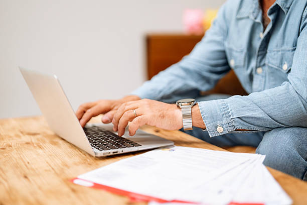 istock Individual working on laptop in a cozy workspace surrounded by paperwork during daytime focusing on tasks and productivity at home 2225078759