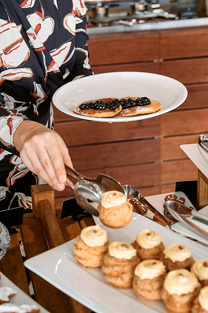 Delicious dessert buffet: pancakes with jam and cream puffs stock photo