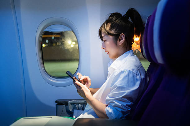 istock Women using mobile phone by airplane windows 2225082317