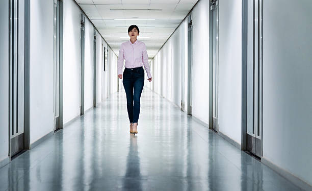 istock Front view of woman walking in a corridor 2225082357