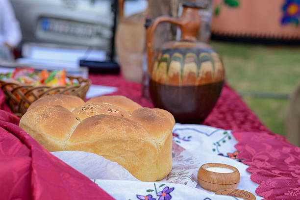 Monumental Serbian serving bread with salt, and bottle with rakia in background