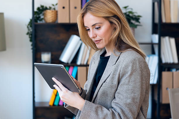 istock Beautiful lawyer woman working with digital tablet while standing in her modern office 2225090860
