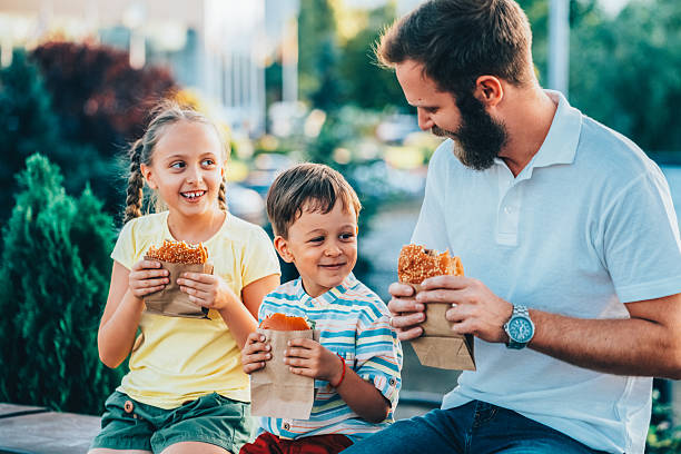 istock Single father with kids eating fast food outside 2225093723