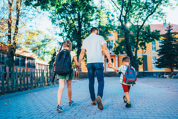 istock Father taking his daughter and son to school 2225094224