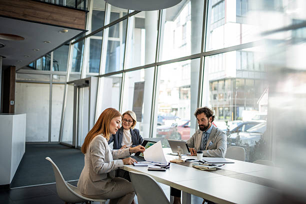Businesspeople working together in modern office analyzing financial reports