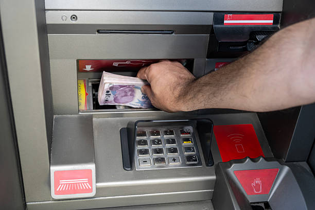 Counting and withdrawing Turkish Lira banknotes from an ATM machine