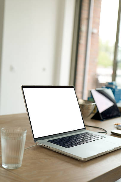 istock Laptop showing blank screen on wooden table in home office setup 2225099205