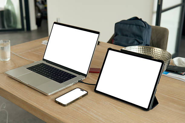 Laptop, tablet and smartphone are showing blank screen on wooden table, ready for your customize