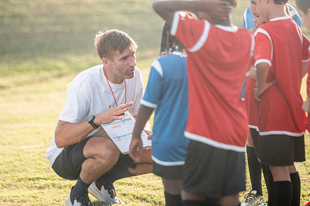 istock Soccer Coach Giving Instructions to Young Players During Team Practice 2225101382