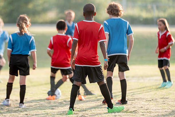 istock Children Playing Soccer Game Outdoors in Red and Blue Team Jerseys 2225101472