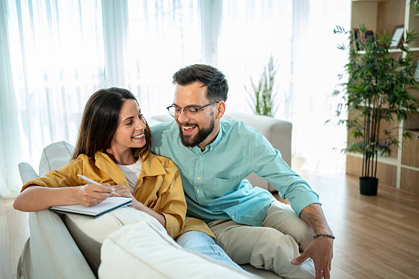 istock Young couple relaxing on sofa planning future at home 2225101497