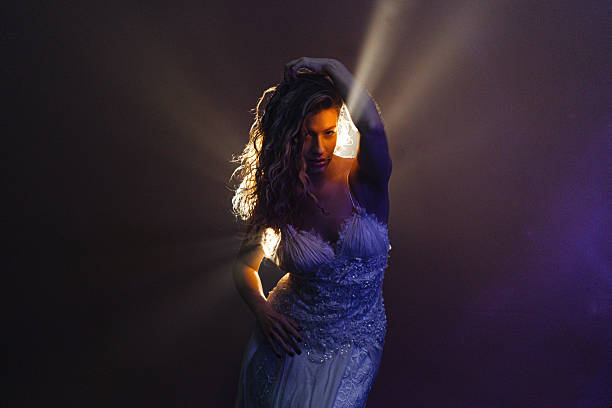istock Cinematic shot of elegant dancer in white, illuminated by dramatic 2225102792