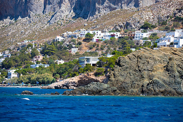 Coastal Village Scene with White Buildings and Rocky Outcrop on the Greek island of Telendos