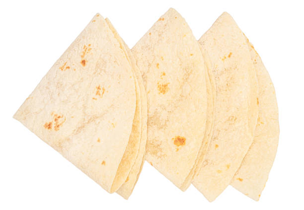 Soft flour tortillas folded and stacked on a white background, perfect for wraps, burritos, tacos or other delicious recipes.