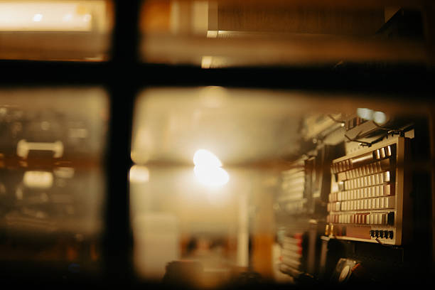 A quiet, intimate look into a cinematic desk setup through window blinds. The soft warm lighting and blurred lines evoke a nostalgic and reflective atmosphere, like a moment paused in time.