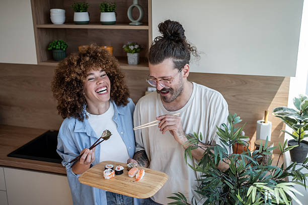 istock Happy couple enjoying sushi together in modern kitchen 2225112500