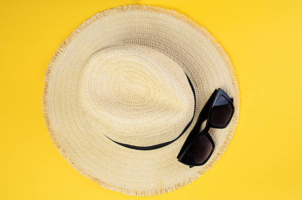 istock Straw hat and black sunglasses on bright yellow background summer vacation concept 2225112608