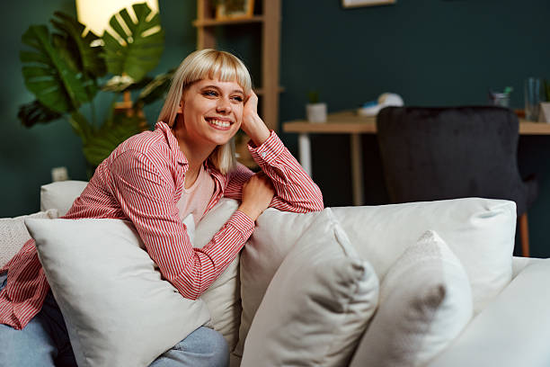 istock Happy woman relaxing on comfortable sofa at home 2225112757