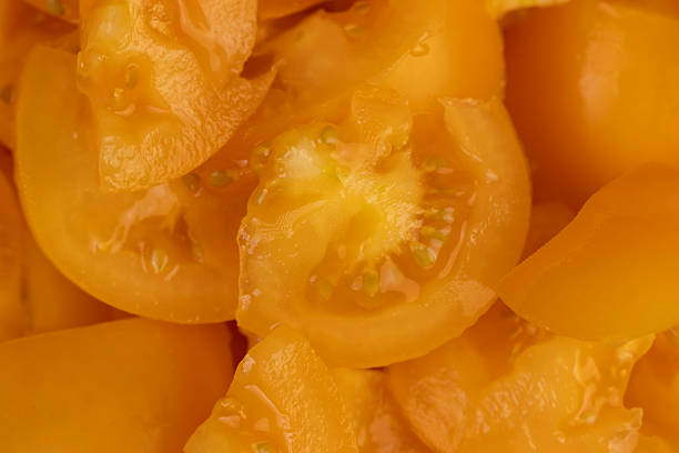 ripe tomatoes cut into pieces of different sizes , clean washed tomatoes are sliced for salad preparation