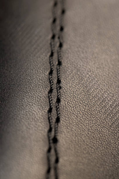 Tailor's hand securing jacket seams with sewing pins while on dressmaker's model, small business salon