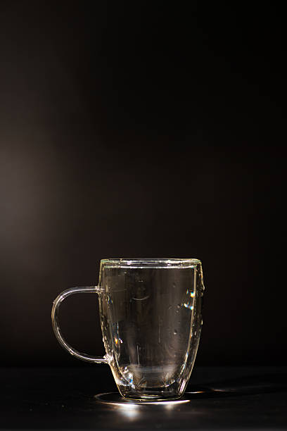 Water, a glass mug with water, black background, selective focus.