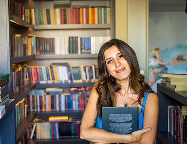istock Woman Hugging a Book in Cozy Bookstore Corner 2225118746