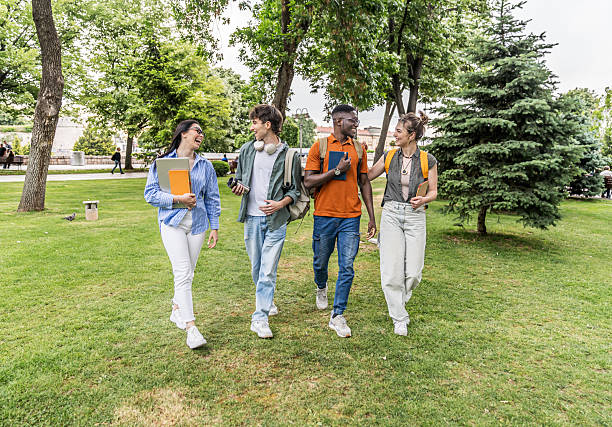 istock Cheerful university students walking and talking in a park 2225122786