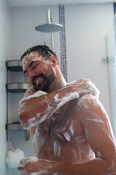 istock Young happy man showering in the morning 2225127723