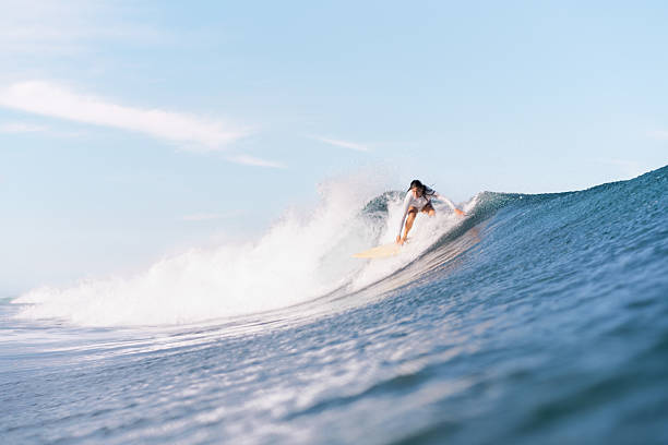 istock Surf girl taking off on wave 1 2225129006