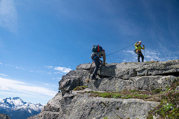 istock Climbing guide belays guest up mountain 2225129981