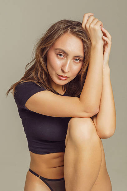 istock Young woman demonstrating skincare routine in a simple studio setting for a fresh look 2225130691