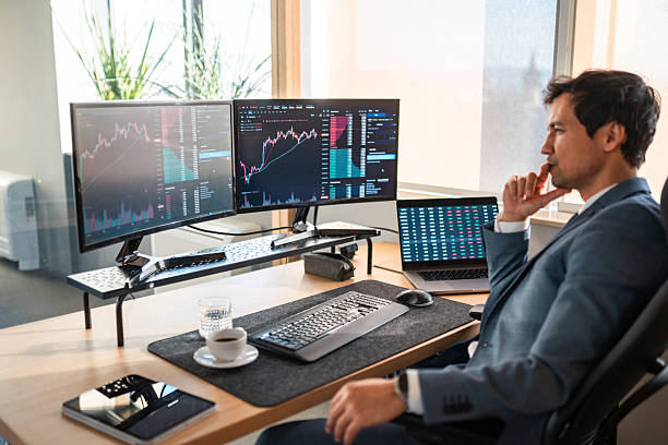 istock Focused Asian Stock Broker Analyzing Market Data in Modern Office 2225134543